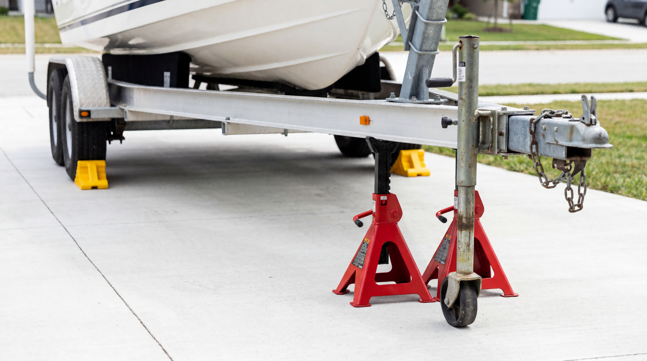 old trailer tongue jack being supported and removed with jack stands in place during trailer jack replacement